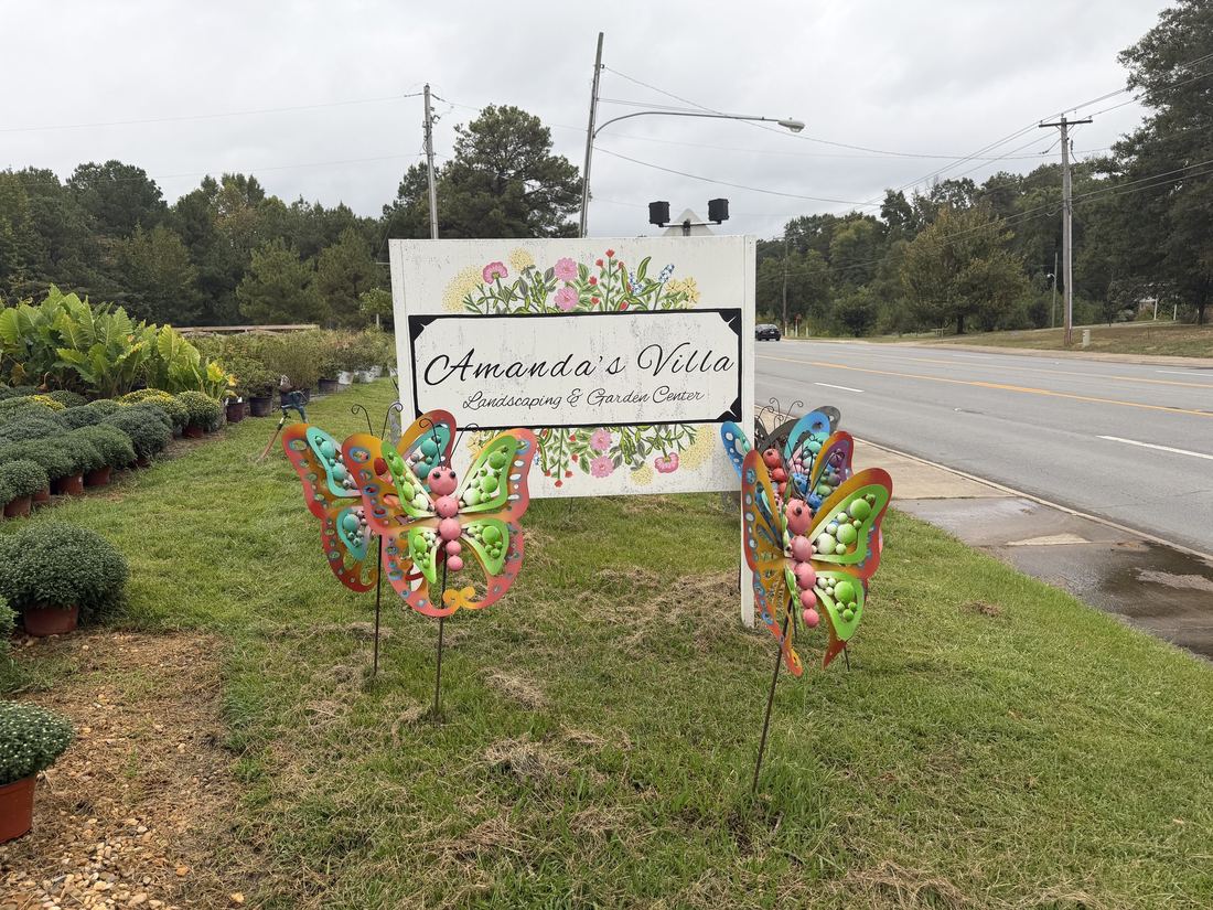 The Amanda's Villa Landscaping and Garden Center roadside sign with metal butterfly ornaments