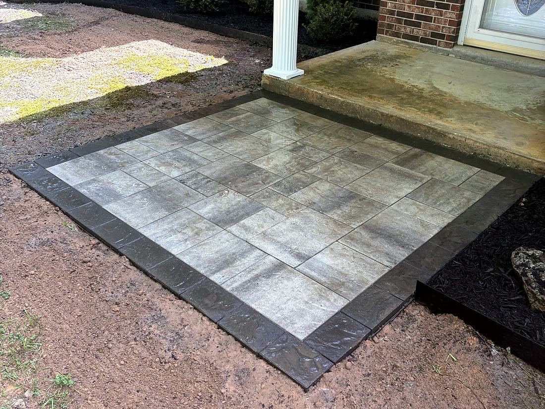 After: A gray paver landing with a charcoal border at the front door.