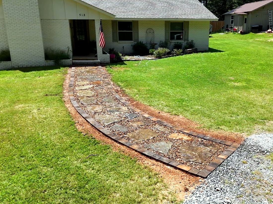 After: A curved flagstone walkway with a brick border, set on a packed gravel base.