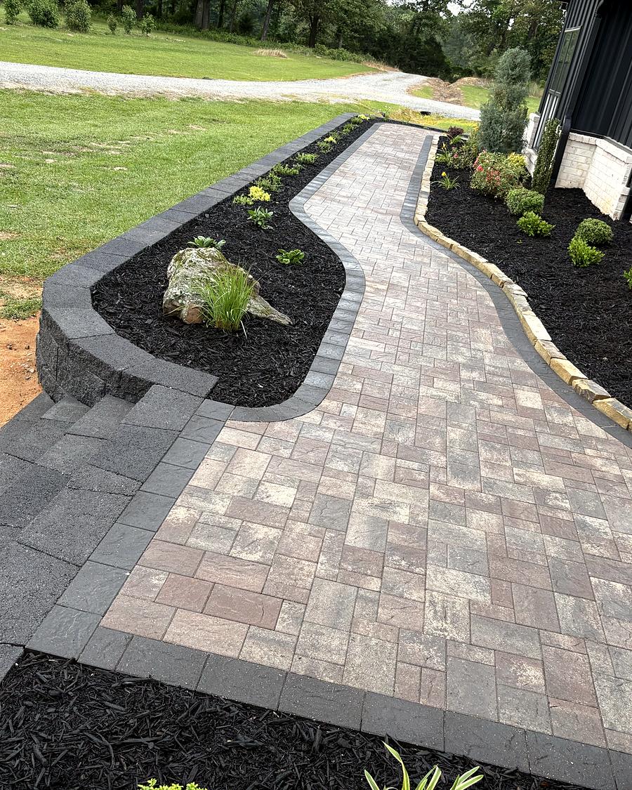 A wide paver walk curving between new beds, built by Amanda's Villa