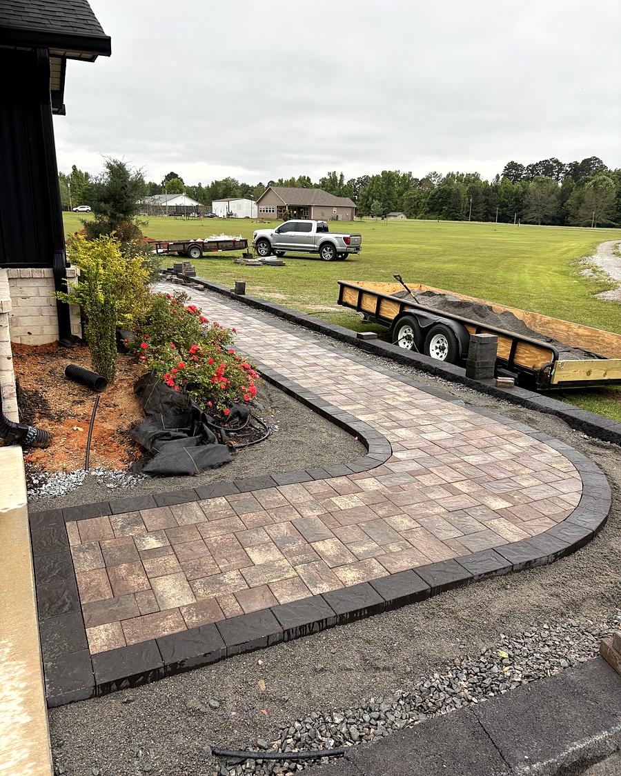 An L-shaped paver walkway beside the house, built by Amanda's Villa