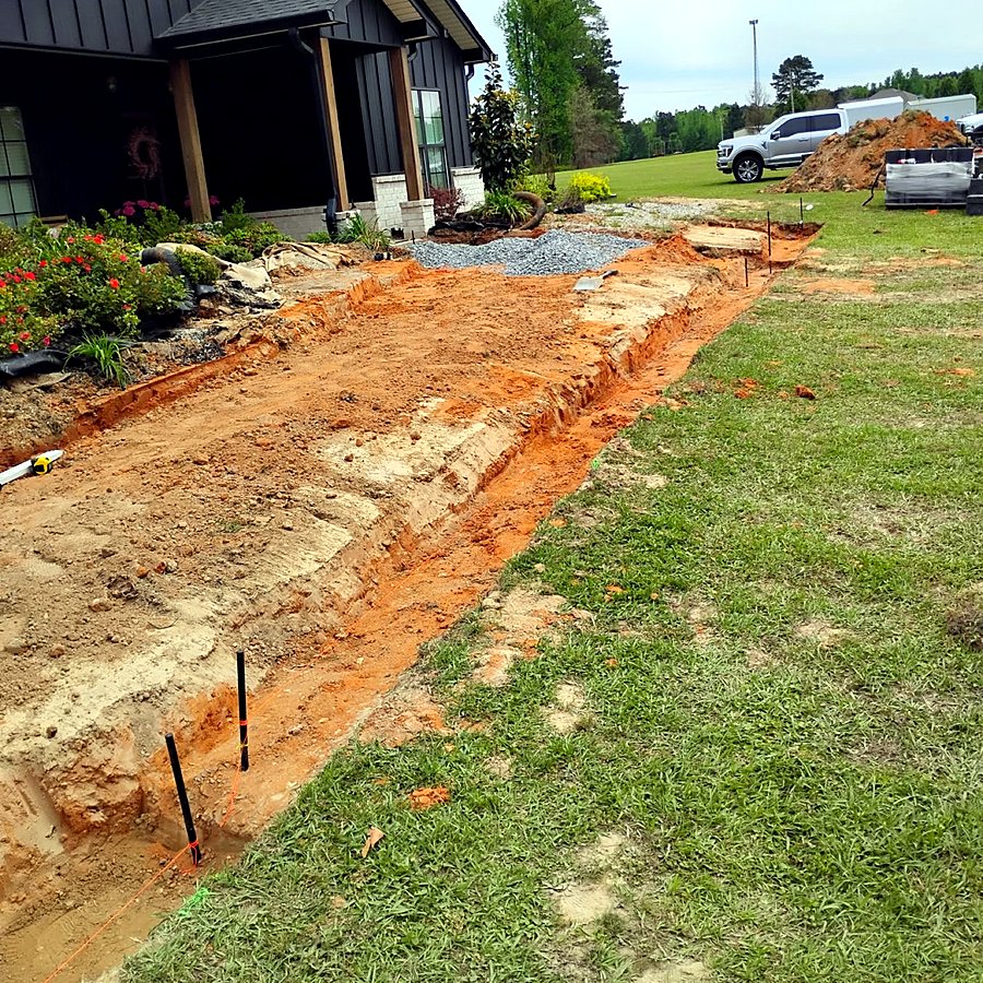 A trench staked and flagged for a new paver walk during layout
