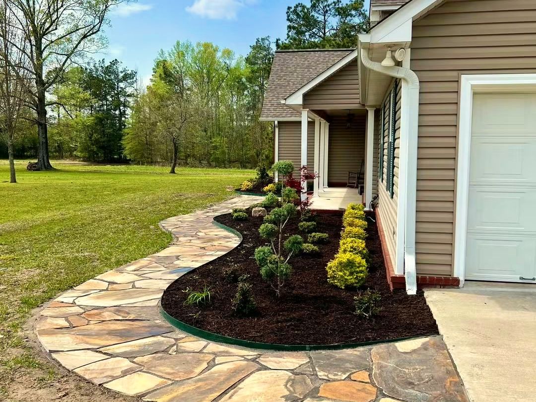 After: A planted bed with steel edging beside a new flagstone walk.