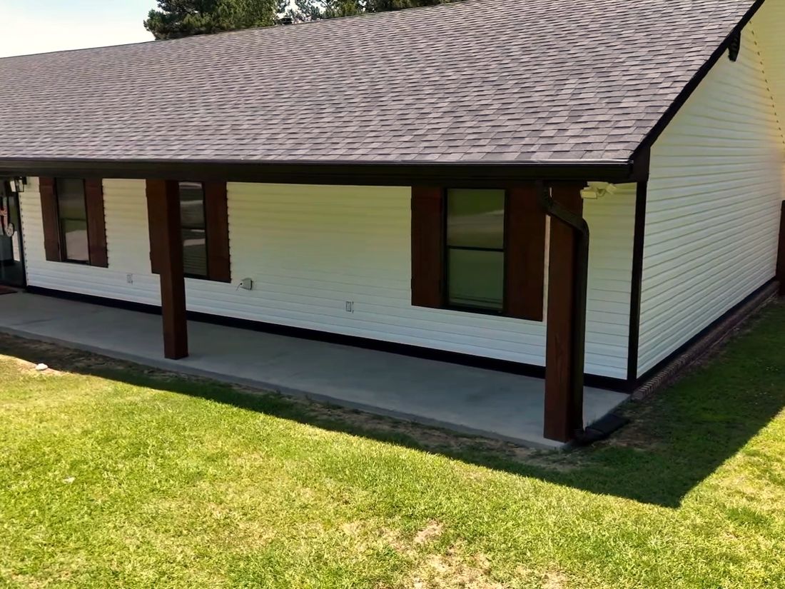 Before: Plain lawn up to the corner of a white ranch house