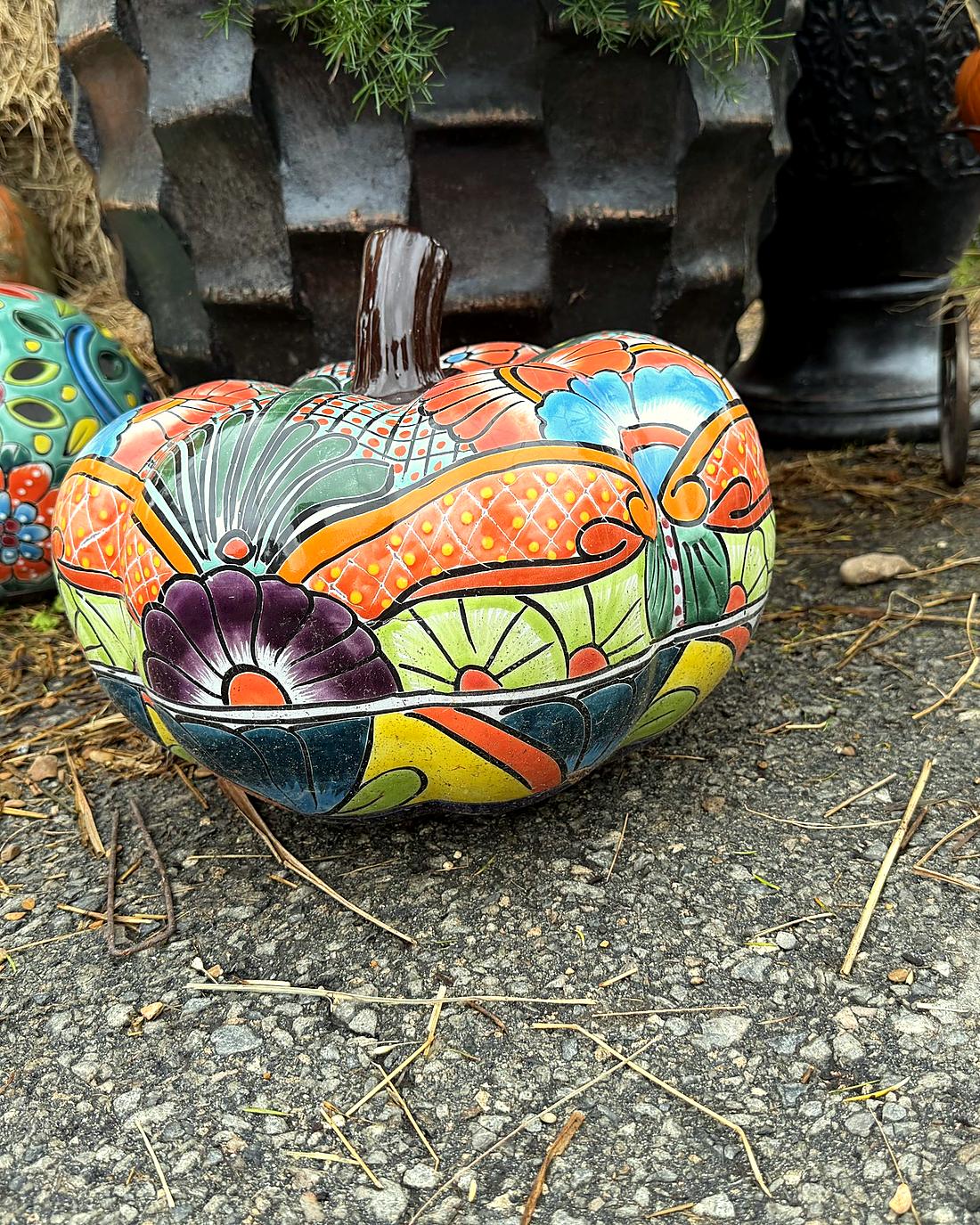 A hand-painted Talavera ceramic pumpkin among fall decor at Amanda's Villa Garden Center