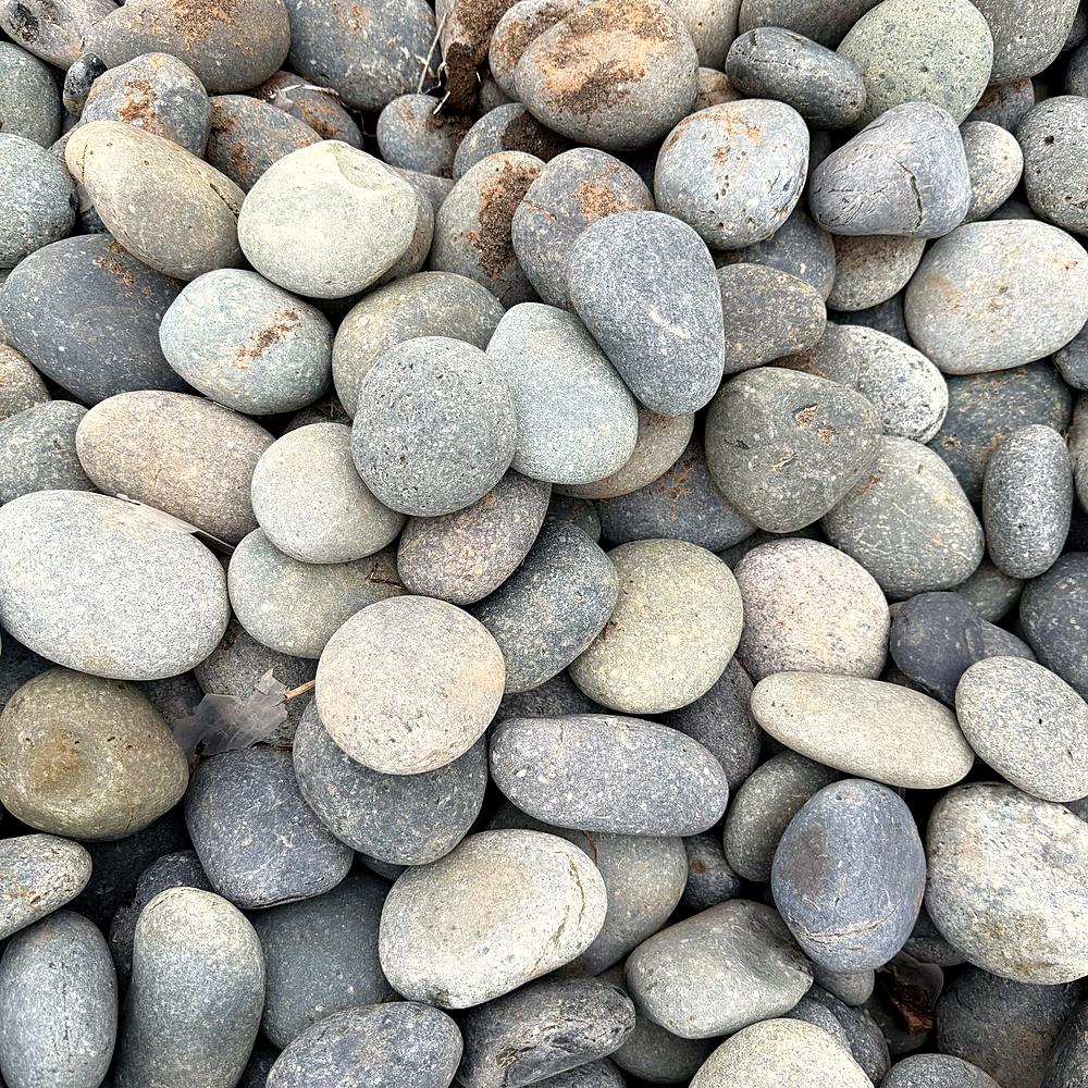 Close-up of smooth gray river rock sold for landscaping at Amanda's Villa