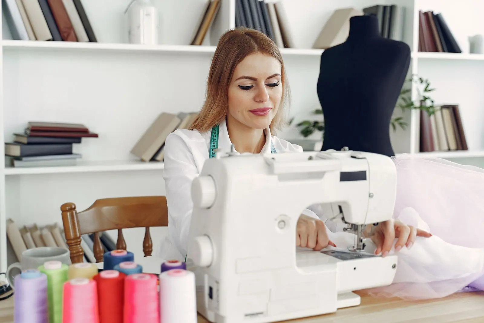 A woman smiling at her sewing machine