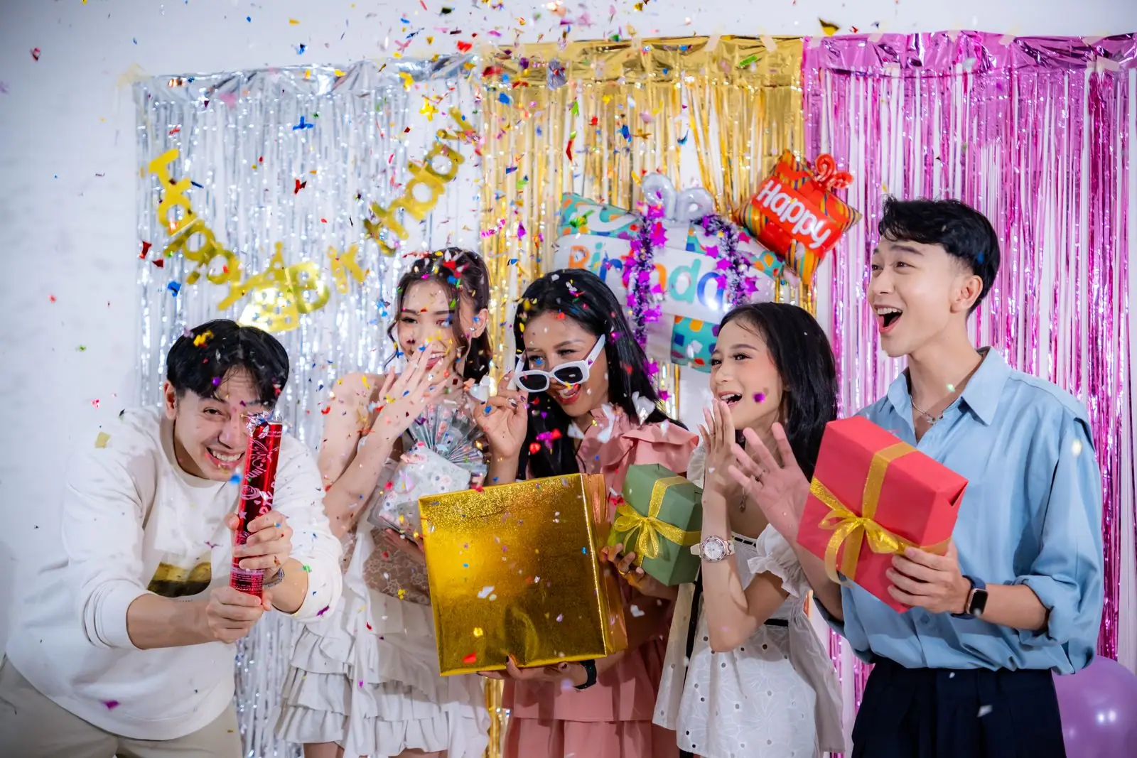Friends laughing as confetti falls